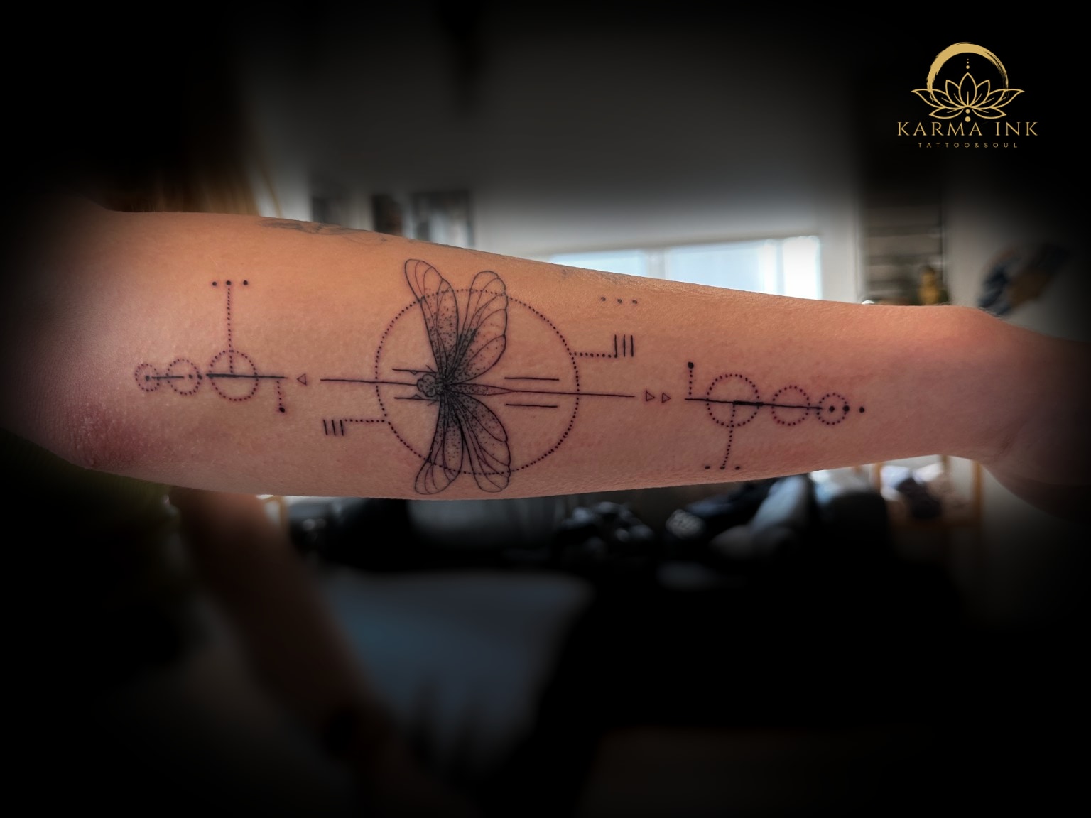 Filigranes Libellen-Tattoo mit geometrischen Linien am Unterarm