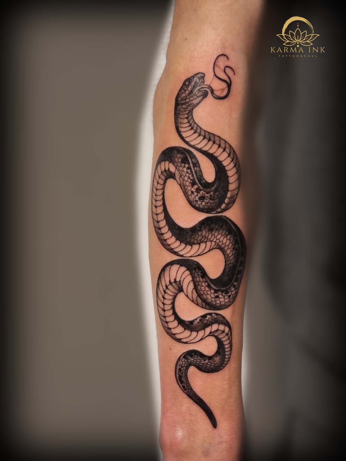 Schwarzes Schlangen-Tattoo am Unterarm