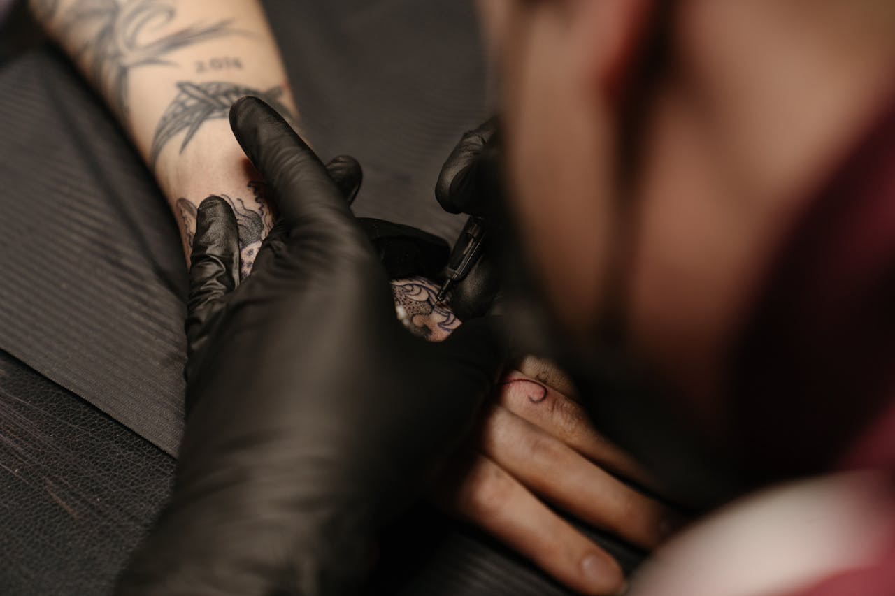 menu-05 Tattoo artist working on a detailed freehand design on a client's arm.